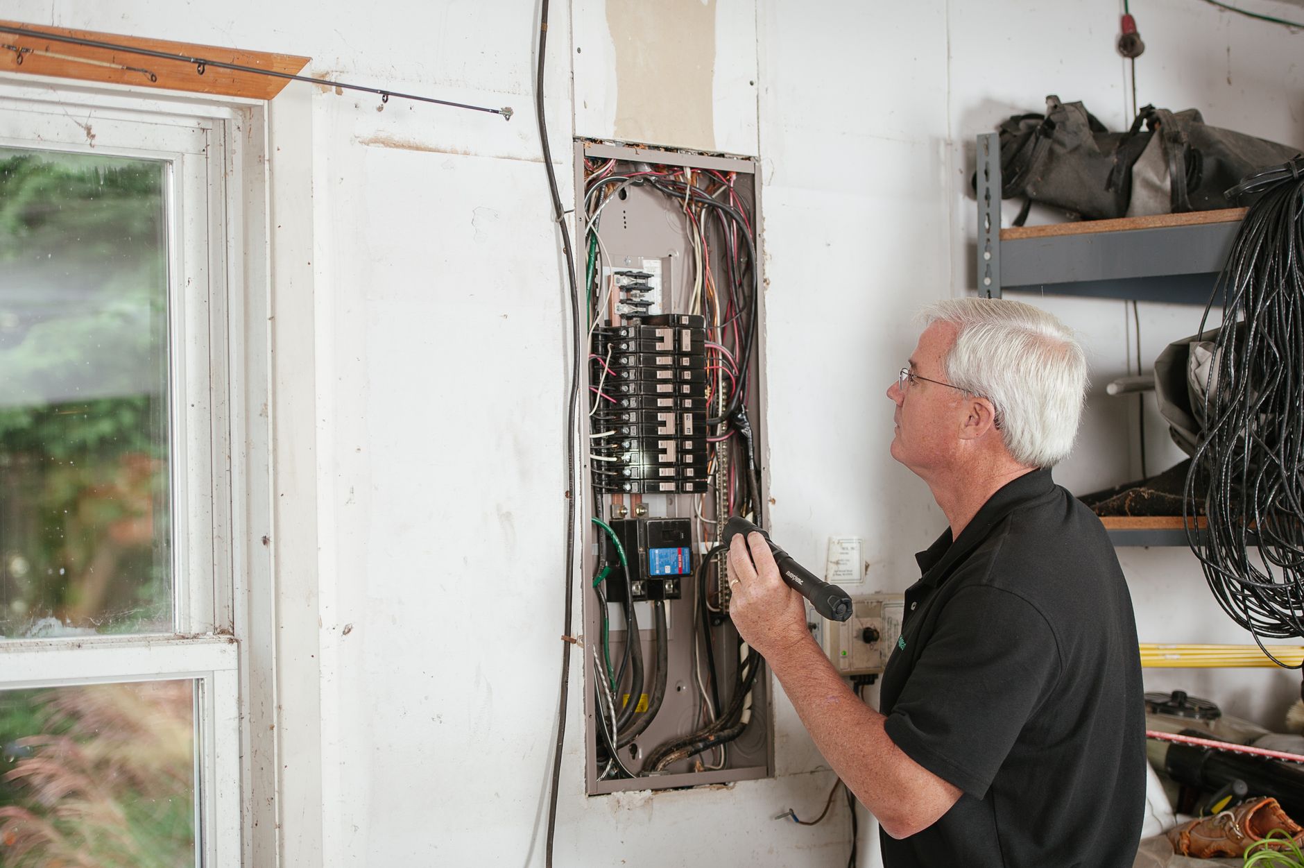 technician inspecting a dryer wall box on an exterior wall